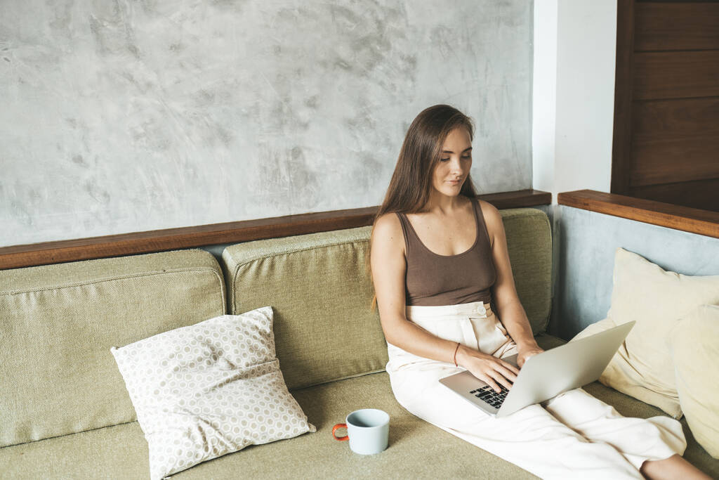 Woman working from home at the computer on the sofa. Copy space - Photo, Image