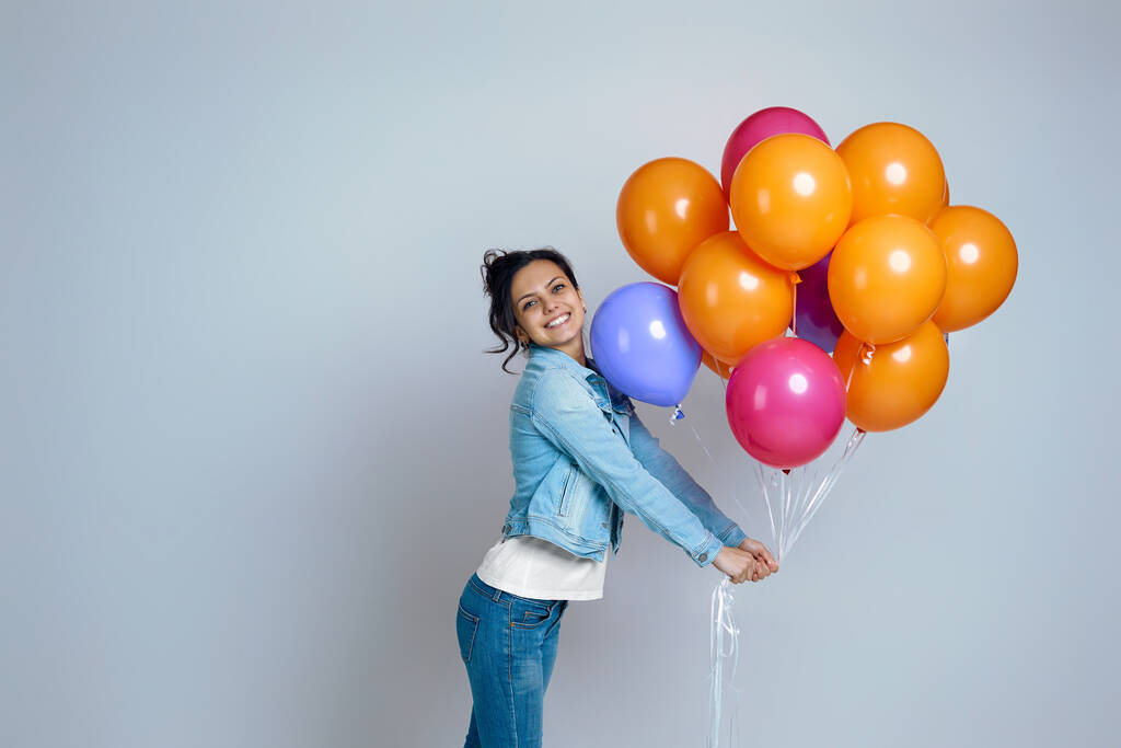 κορίτσι σε denim ποζάρουν με φωτεινά πολύχρωμα μπαλόνια αέρα - Φωτογραφία, εικόνα