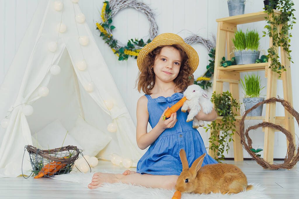 Pequeña linda chica alimenta zanahorias esponjoso conejo mascota, el cuidado y la vida con animales. Feliz infancia. - Foto, imagen