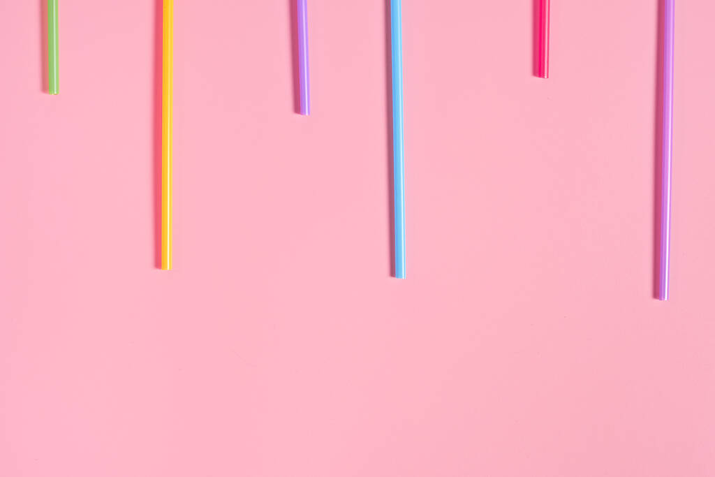 Lignes de pailles colorées pour boisson sur table rose. Espace pour le texte. Vue du dessus
 - Photo, image