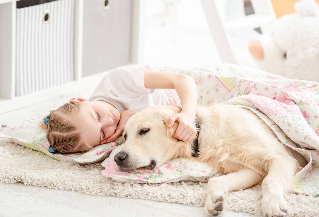 Klein meisje met hond onder deken - Foto, afbeelding