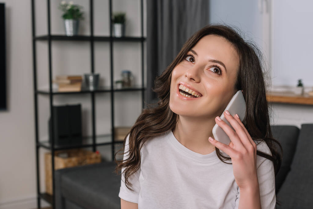 fröhliche Frau lächelt beim Telefonieren auf dem Smartphone  - Foto, Bild