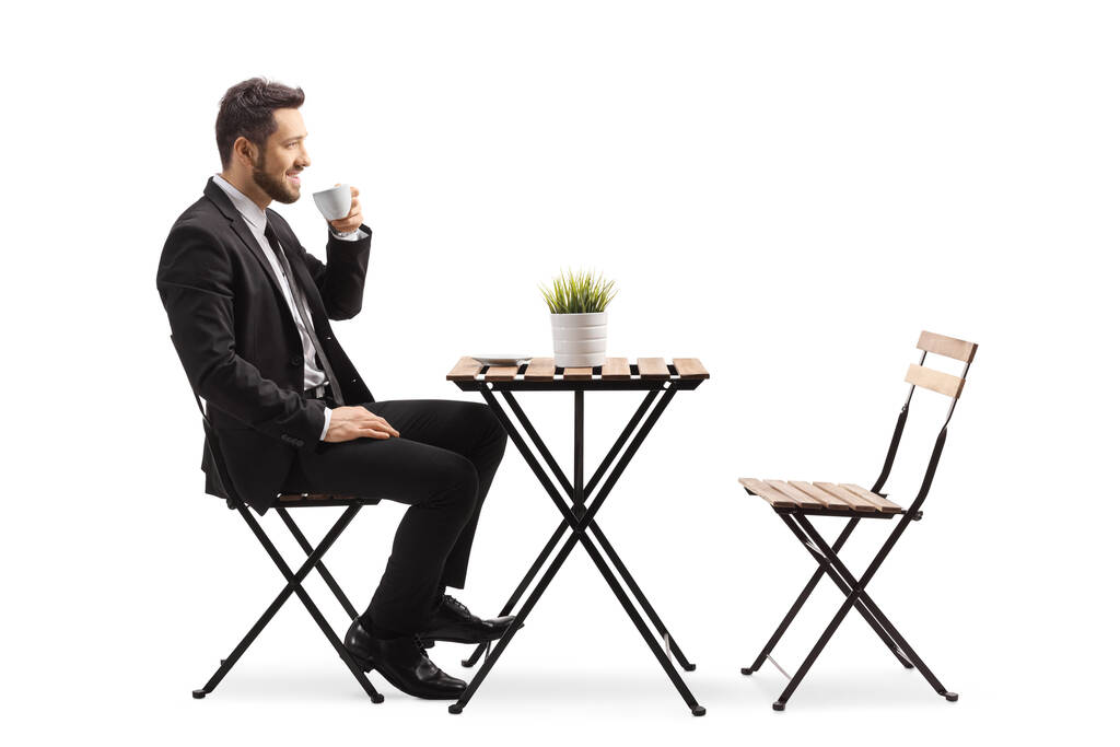 ビジネスマンがカフェに座って白い背景に隔離されたエスプレッソコーヒーを飲む - 写真・画像