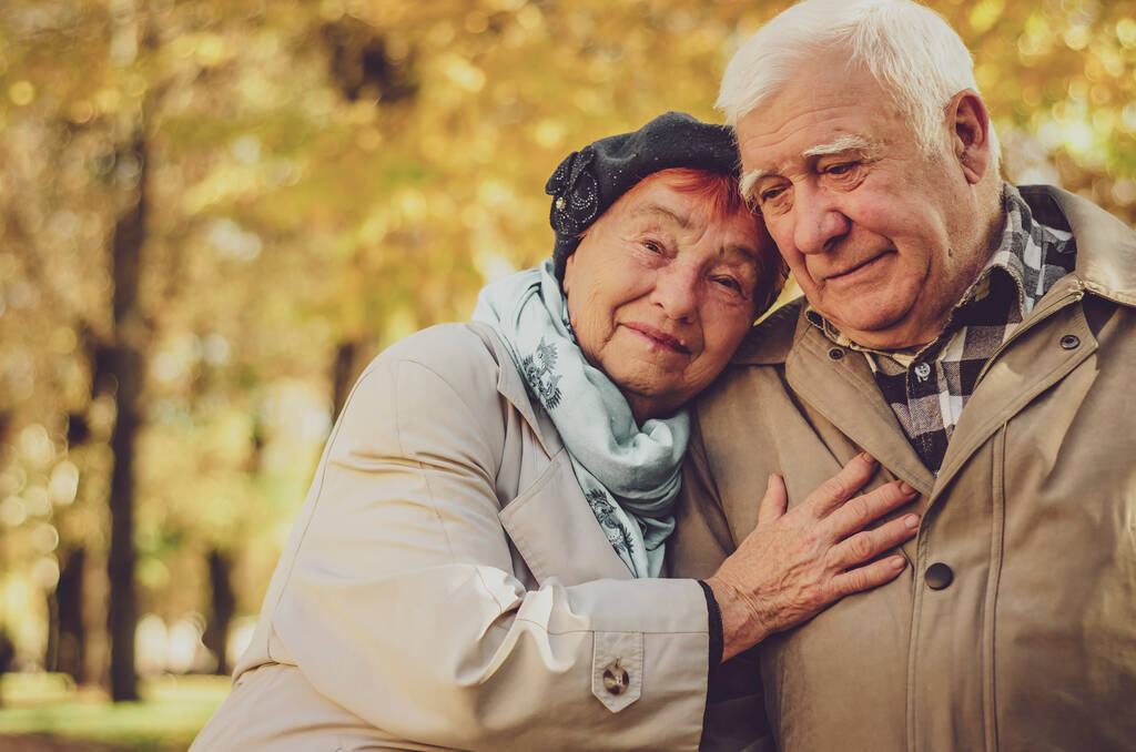 Ein älteres Ehepaar sitzt auf einer Bank und blickt traurig nach unten. Summe, Traurigkeit, Alter, Langeweile, Schmerz, Verlust, Gefühl der Verwüstung. - Foto, Bild