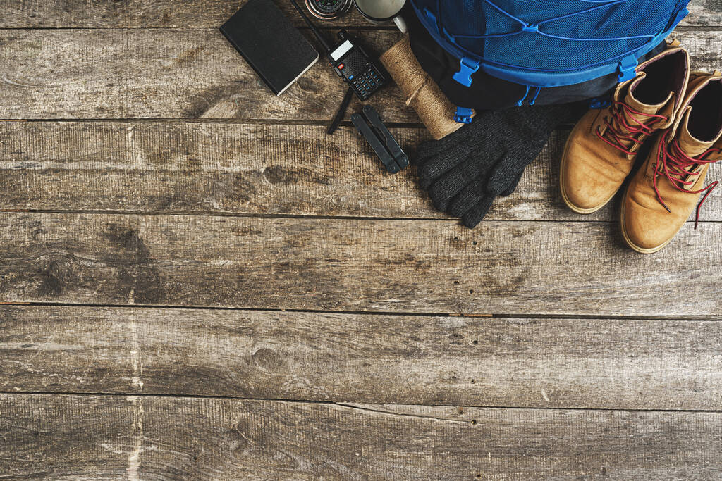 Σακίδιο πλάτης και εξοπλισμός πεζοπορίας σε ξύλινο φόντο, κορυφαία προβολή - Φωτογραφία, εικόνα
