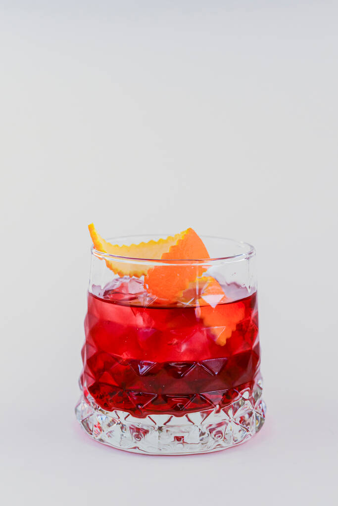 Cocktail froid à l'alcool d'été avec glace et orange dans un petit verre isolé sur fond blanc. - Photo, image
