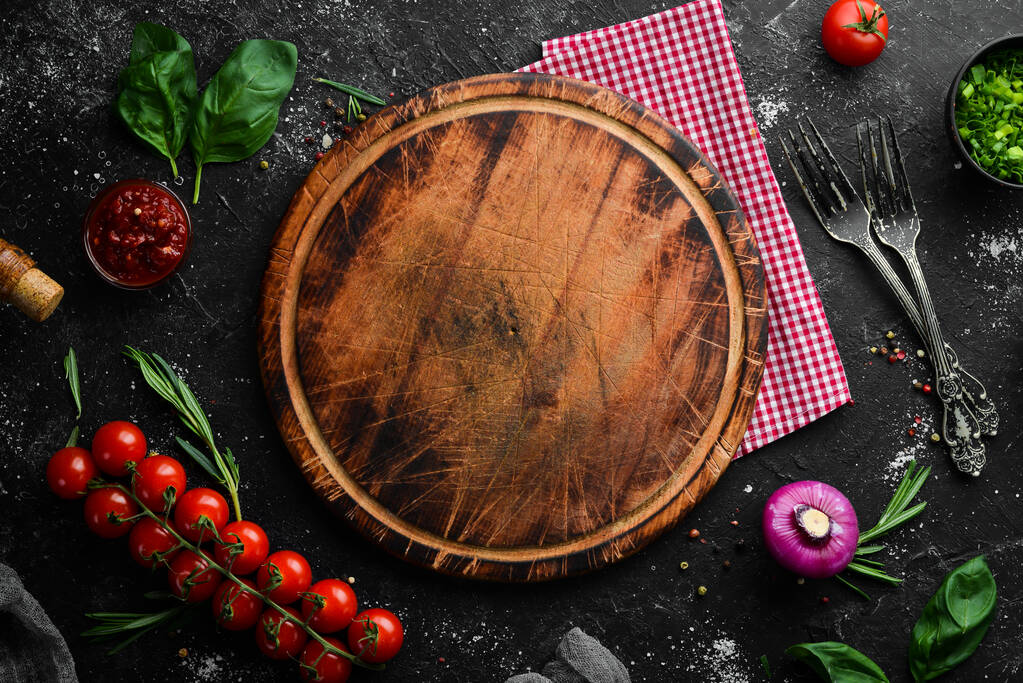 Food background. Kitchen board, vegetables, spices and kitchen utensils on the old table. Free copy space. - Photo, Image
