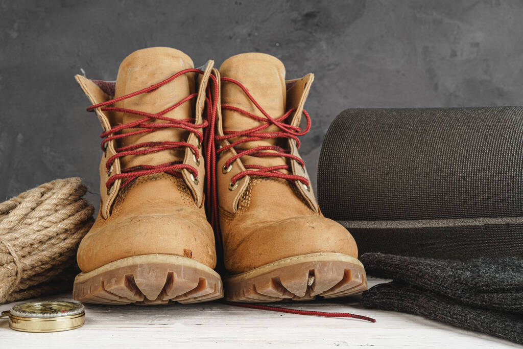 Hiking boots and rope hank on wooden board - Photo, Image