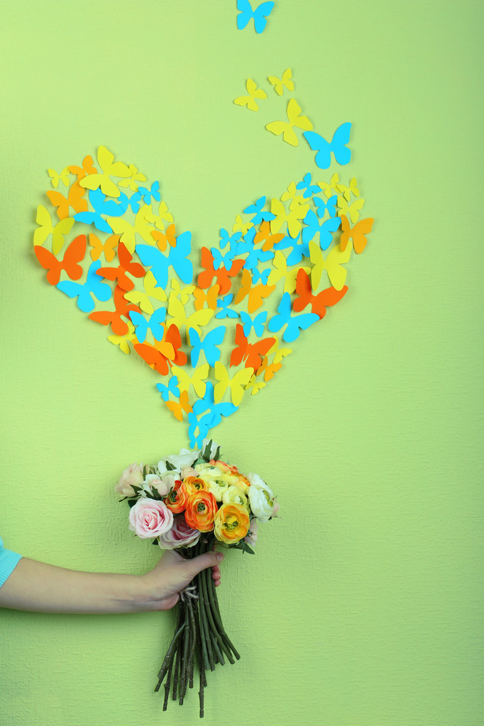 χαρτί πεταλούδες πετούν από λουλούδια, σε φόντο πράσινο τοίχο - Φωτογραφία, εικόνα