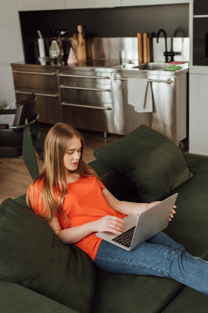 schöne und junge Freiberuflerin mit Laptop im Wohnzimmer  - Foto, Bild