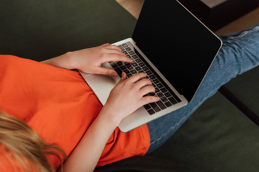 обрезанный вид молодой фрилансер с помощью ноутбука с чистым экраном в гостиной
  - Фото, изображение