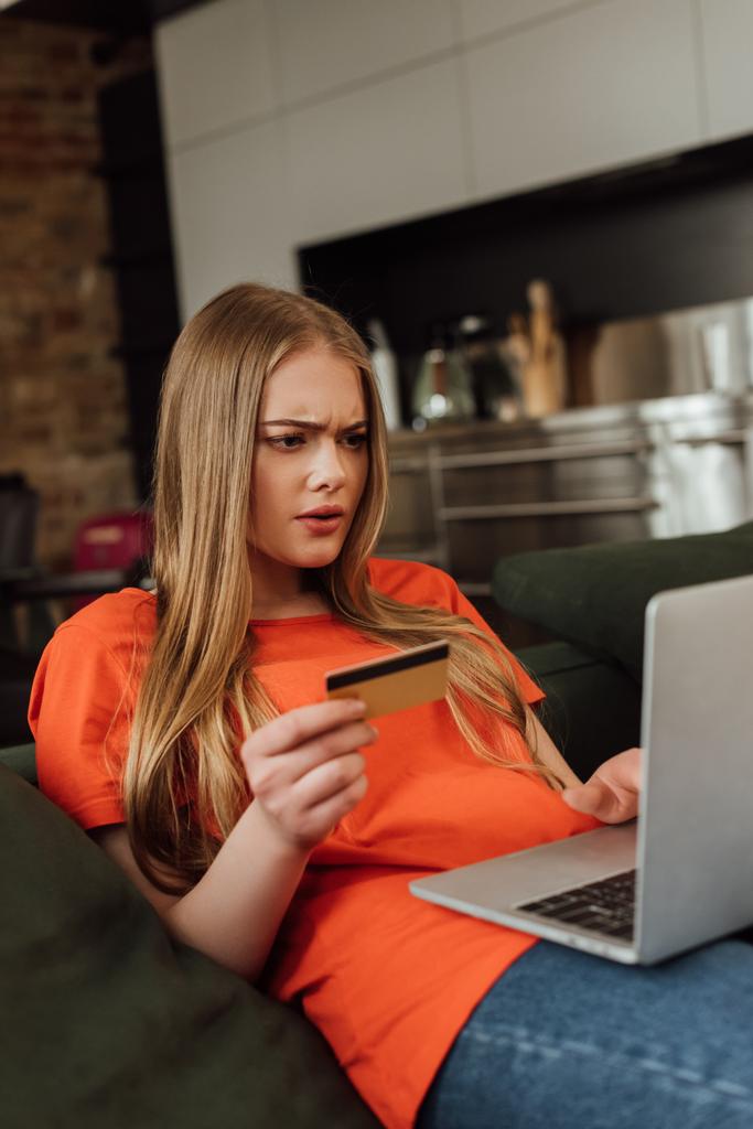 szelektív fókusz összpontosított nő gazdaság hitelkártya közelében laptop  - Fotó, kép