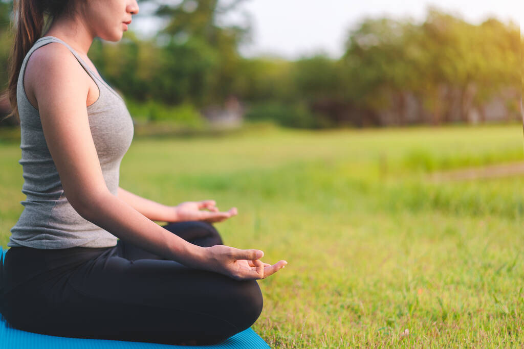 Mulher asiática meditando e sentar-se na pose de lótus no parque, conceito saudável e Yoga, conceito de melhorias mente-corpo, foco seletivo, espaço de cópia. - Foto, Imagem