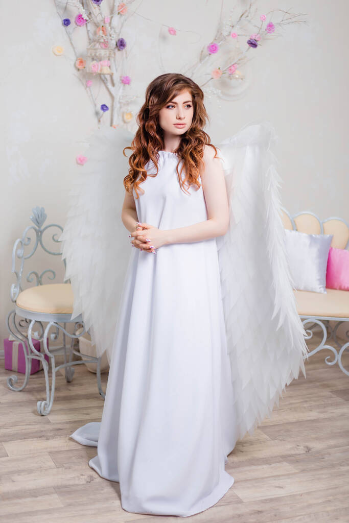 Молода жінка в білій сукні з ангельськими крилами
. - Фото, зображення
