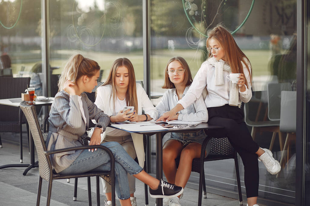 Cuatro estudiantes en un campus de estudiantes sentados a la mesa
 - Foto, Imagen