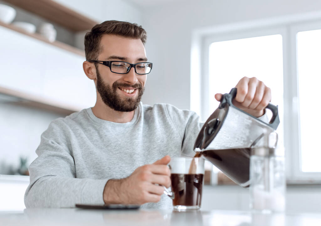 atractivo hombre vertiendo a sí mismo una taza de café de la mañana - Foto, Imagen