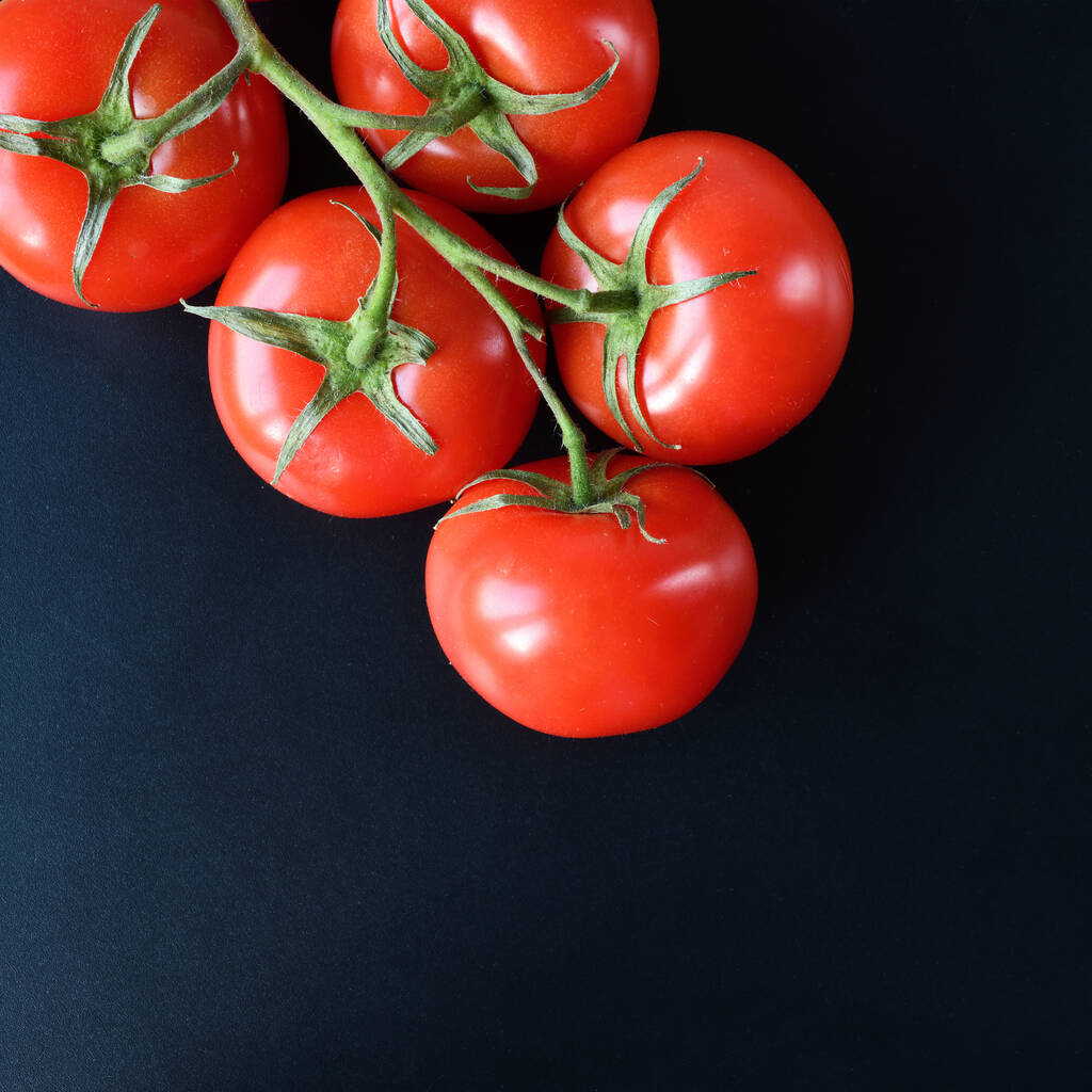 Tomate auf Zweig Draufsicht auf schwarzem Hintergrund. - Foto, Bild