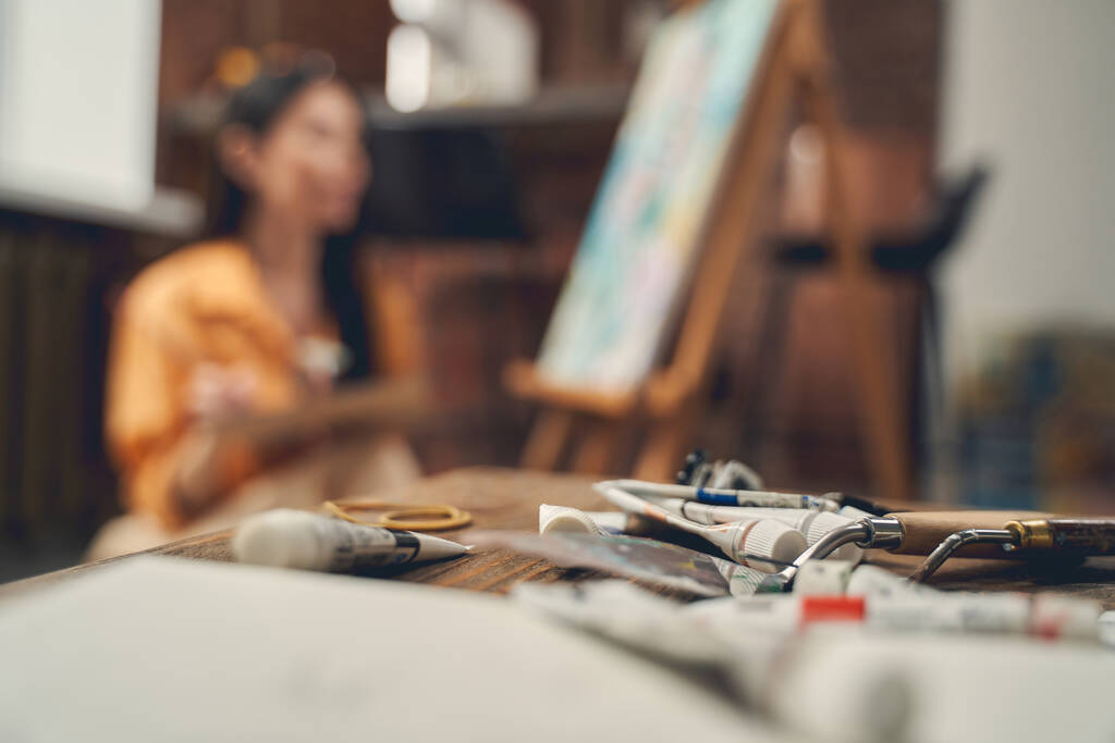 Труби з фарби та палітри на столі в домашній художній студії
 - Фото, зображення