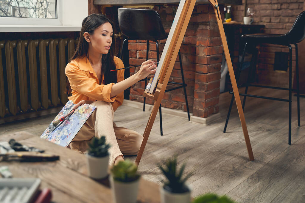 Attrayant tableau jeune femme peinture dans le studio d'art à la maison
 - Photo, image