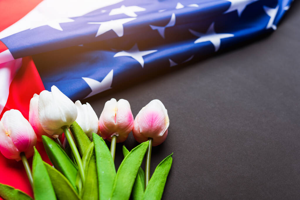 Feliz Día de los Caídos Recuerde que anteriormente, pero ahora rara vez llamado Día de la Decoración, la bandera estadounidense y una flor de tulipán sobre un fondo negro y espacio de copia, una fiesta federal en los Estados Unidos - Foto, Imagen