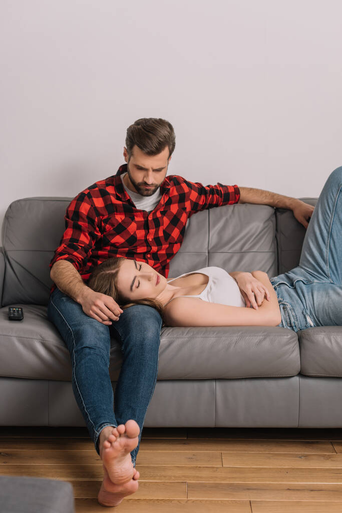 zdenerwowana młoda para na kanapie w domu podczas kwarantanny - Zdjęcie, obraz
