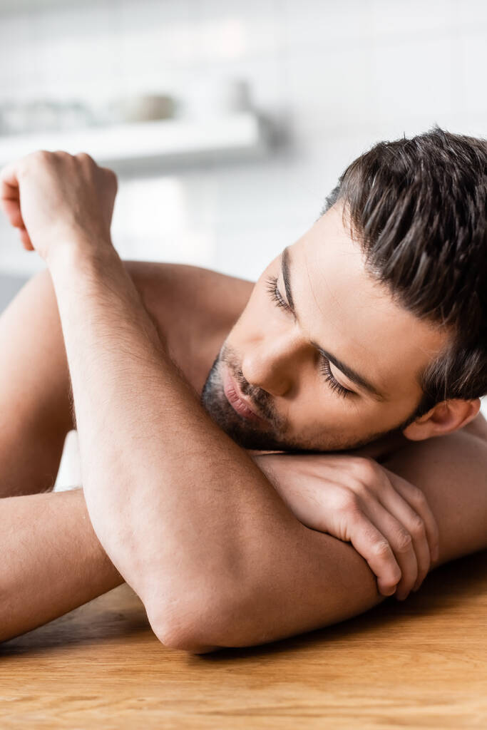 jóképű félmeztelen szexi férfi fekszik a konyhában - Fotó, kép
