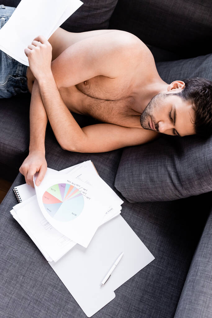 sexy freelancer sleeping with graphic and documents on sofa during quarantine - Photo, Image