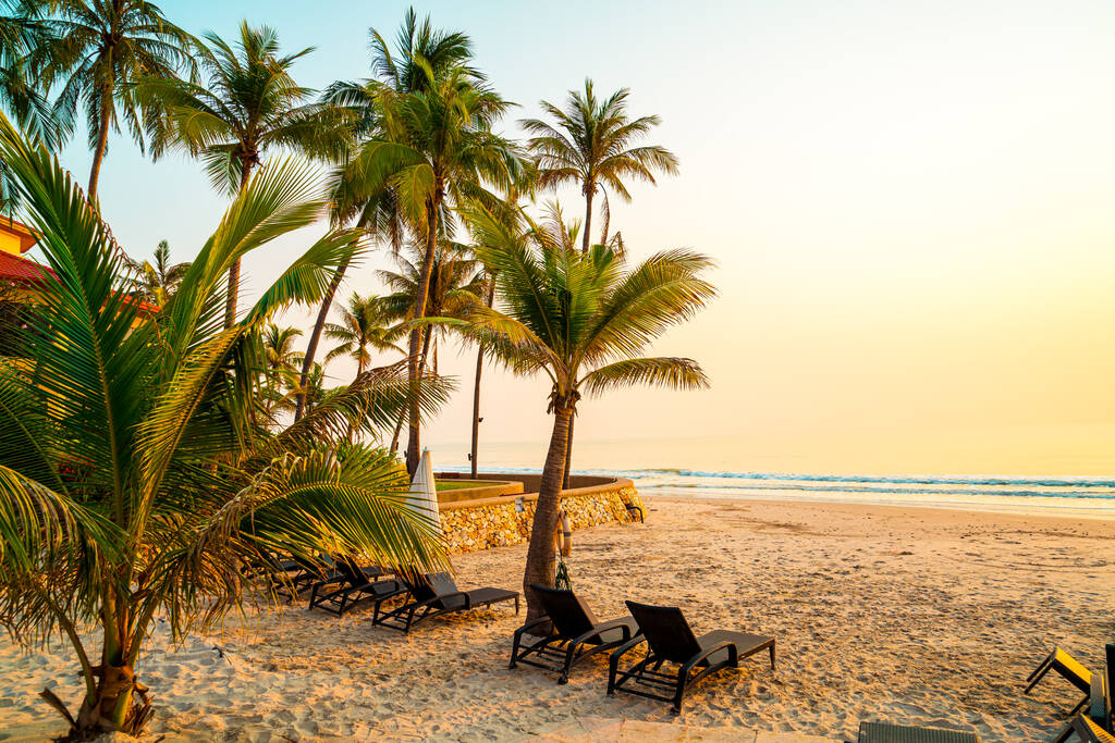 parasol krzesło plaża z palmą i plaży morskiej o wschodzie słońca - koncepcja wakacje i wakacje - Zdjęcie, obraz