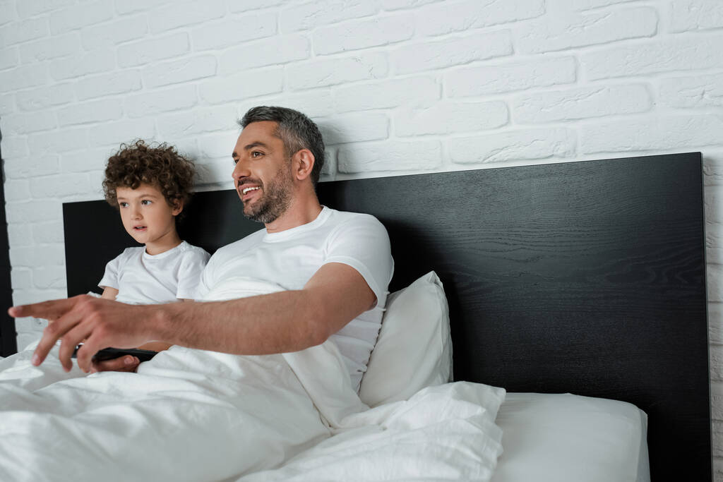 Mutlu babanın oğluyla film izlerken parmağıyla işaret ettiği seçici odaklanma.  - Fotoğraf, Görsel