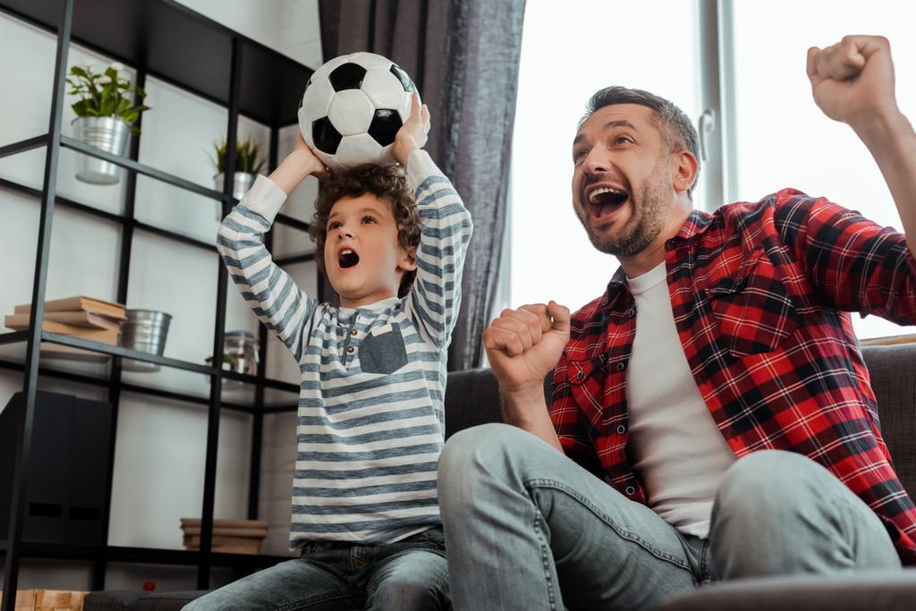 Aufgeregtes Kind beim Fußballgucken mit Vater - Foto, Bild