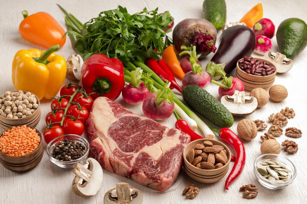 Çiğ et. Sebzeli mermer biftek, fasulye, beyaz arka planda fındık. Doğal protein kaynağı. Üst görünüm - Fotoğraf, Görsel