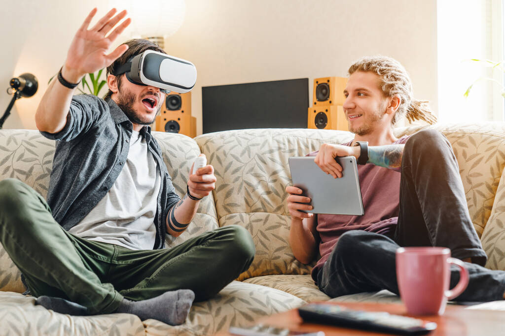 Fiatal barátok szórakozás virtuális valóság szemüveg és digitális tabletta beltéri - Fotó, kép