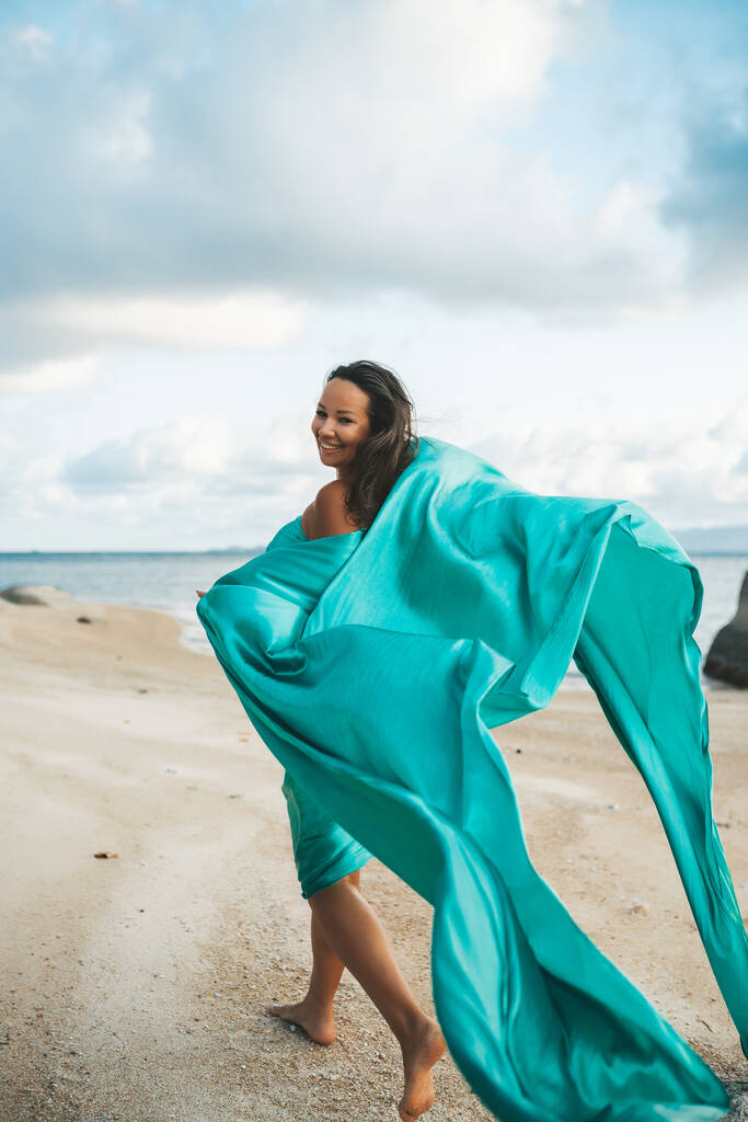 Femme heureuse avec fibre marchant à la plage du coucher du soleil
 - Photo, image