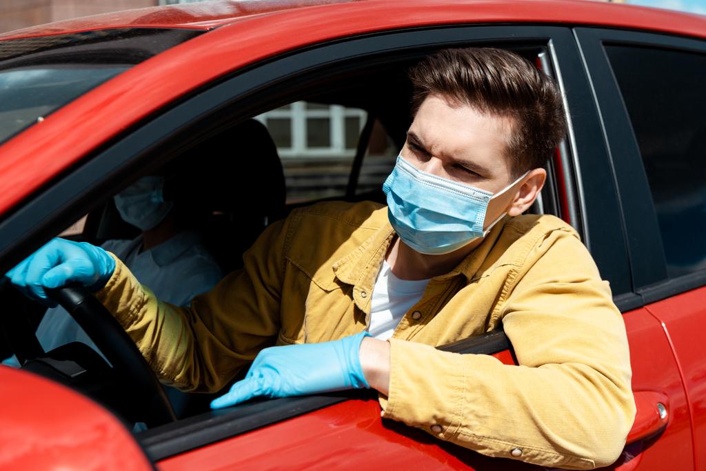 homem em máscara médica e luvas de proteção dirigindo táxi durante a pandemia de coronavírus
 - Foto, Imagem