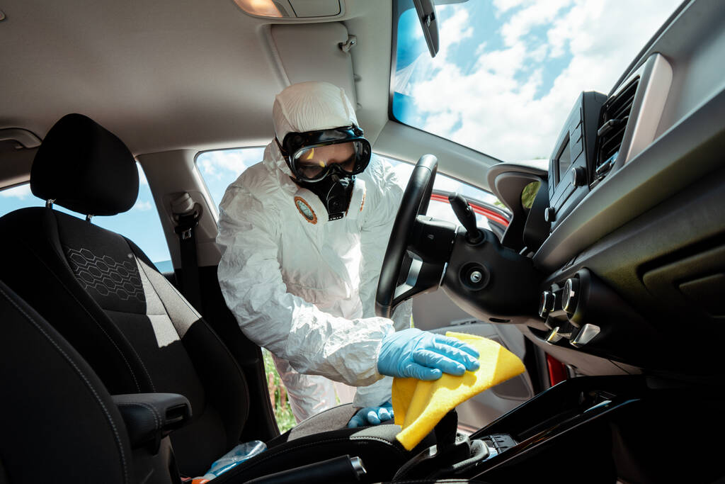 spécialiste en combinaison Hazmat et respirateur nettoyage intérieur de voiture avec chiffon en quarantaine
 - Photo, image