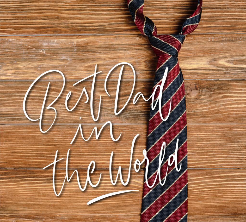 Horní pohled na pánské pruhované tkaniny kravaty na dřevěném pozadí, nejlepší táta na světě ilustrace - Fotografie, Obrázek