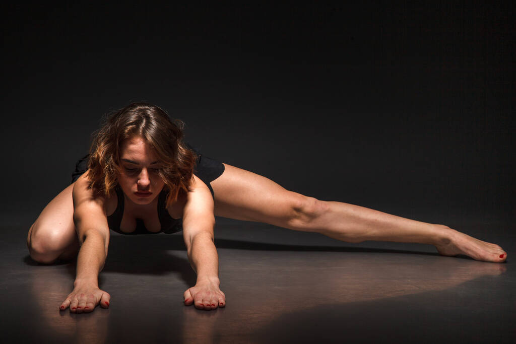 Jeune fille faisant du yoga sur un fond noir
 - Photo, image