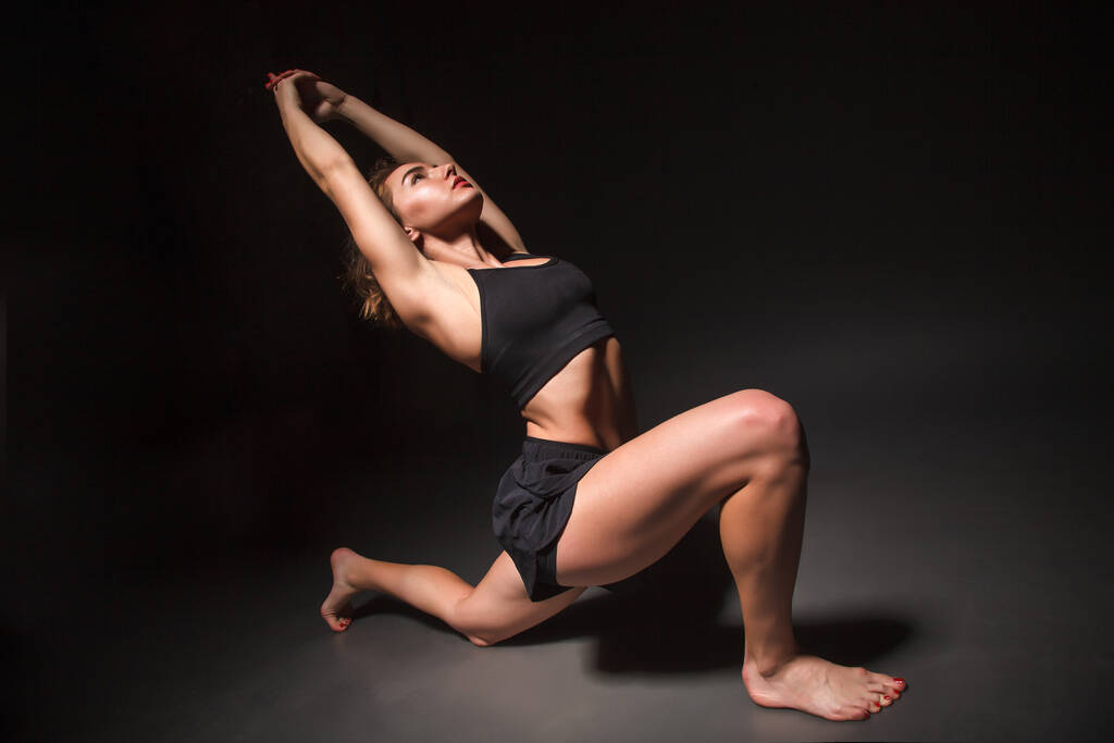 Chica joven haciendo yoga sobre un fondo negro
 - Foto, Imagen