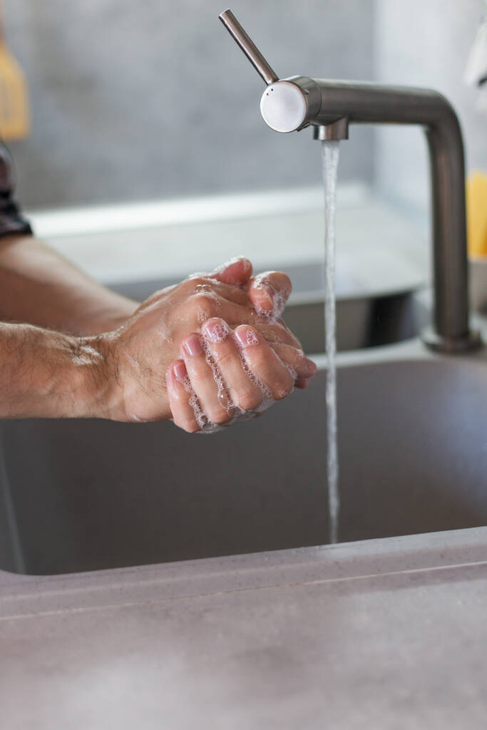 コロナウイルスのパンデミック予防温水石鹸で手を洗う - 写真・画像