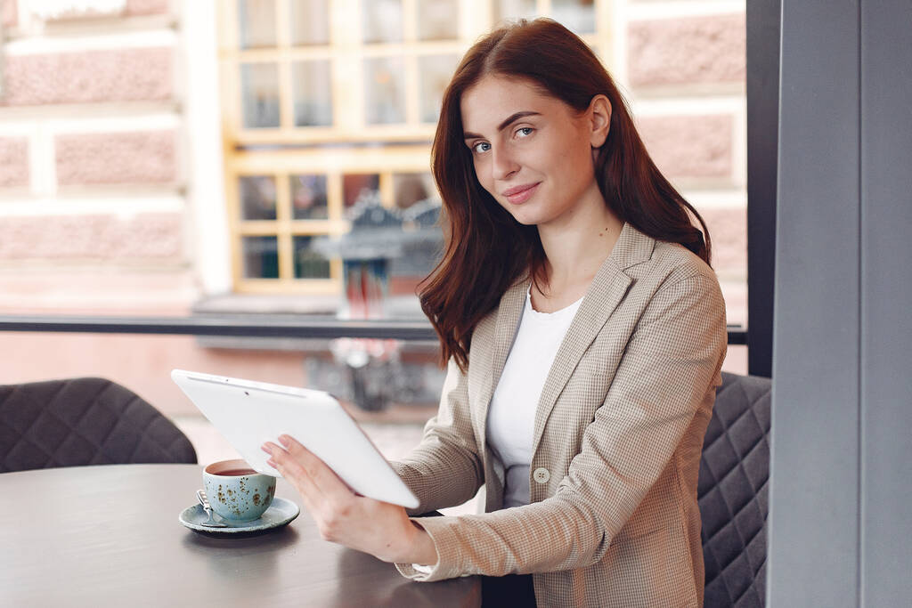Бізнес-леді сидить за столом з планшетом
 - Фото, зображення