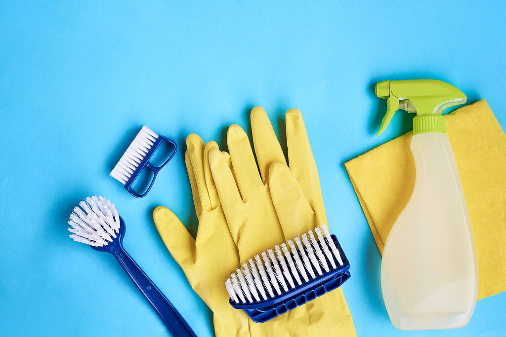 Spazzole per piatti blu, guanti gialli e stracci per la pulizia su sfondo blu. Spazio per testo
 - Foto, immagini