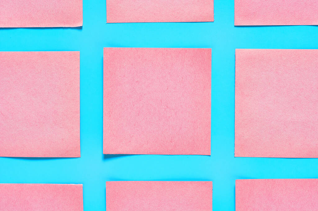 Sorok rózsaszín négyzet üres papír matricák kék háttér. Másold a helyet. Felülnézet - Fotó, kép