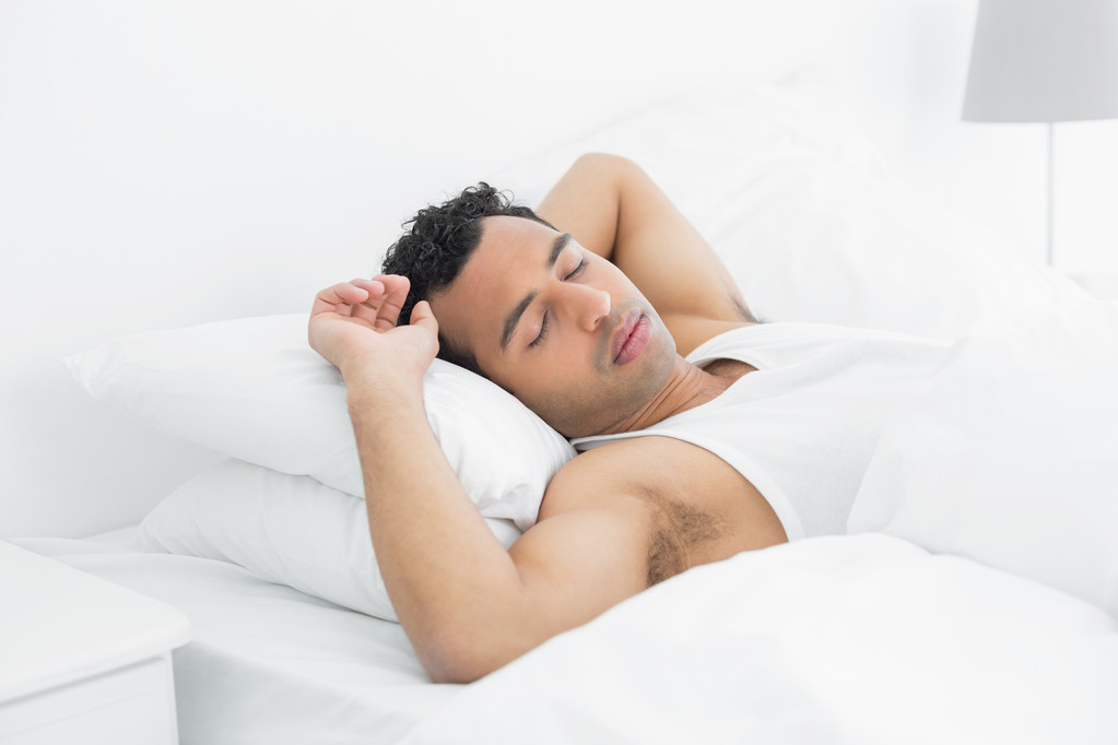 ベッドで寝てる若い男 - 写真・画像