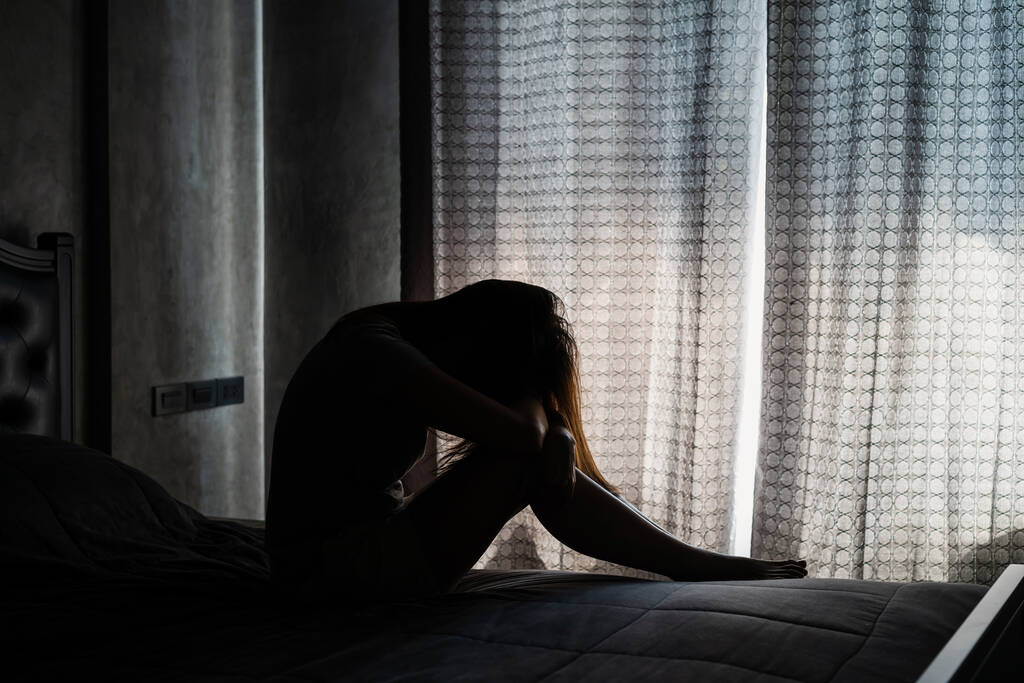 Jovem solitária deprimida e estressada sentada no quarto escuro, conceito de emoção negativa - Foto, Imagem