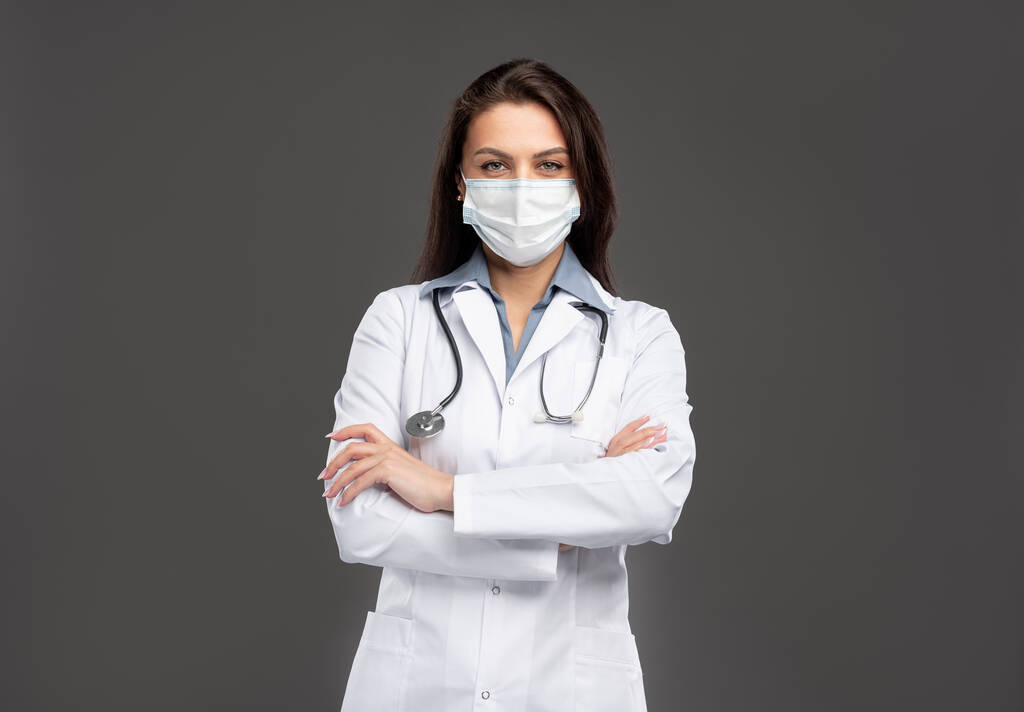Vrouwelijke arts in beschermend masker in studio - Foto, afbeelding