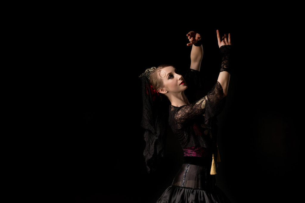 όμορφη χορεύτρια με φόρεμα gesturing ενώ χορό φλαμένκο απομονώνονται σε μαύρο  - Φωτογραφία, εικόνα