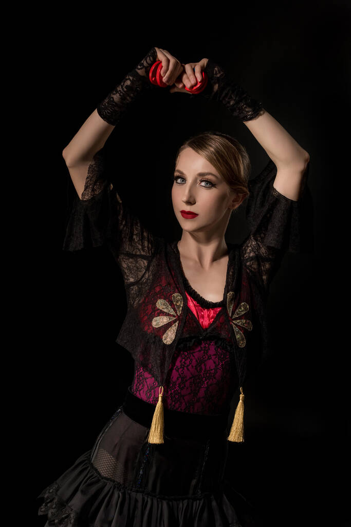 красивая танцовщица, держащая кастаньеты, танцуя фламенко, изолированное на черном
  - Фото, изображение