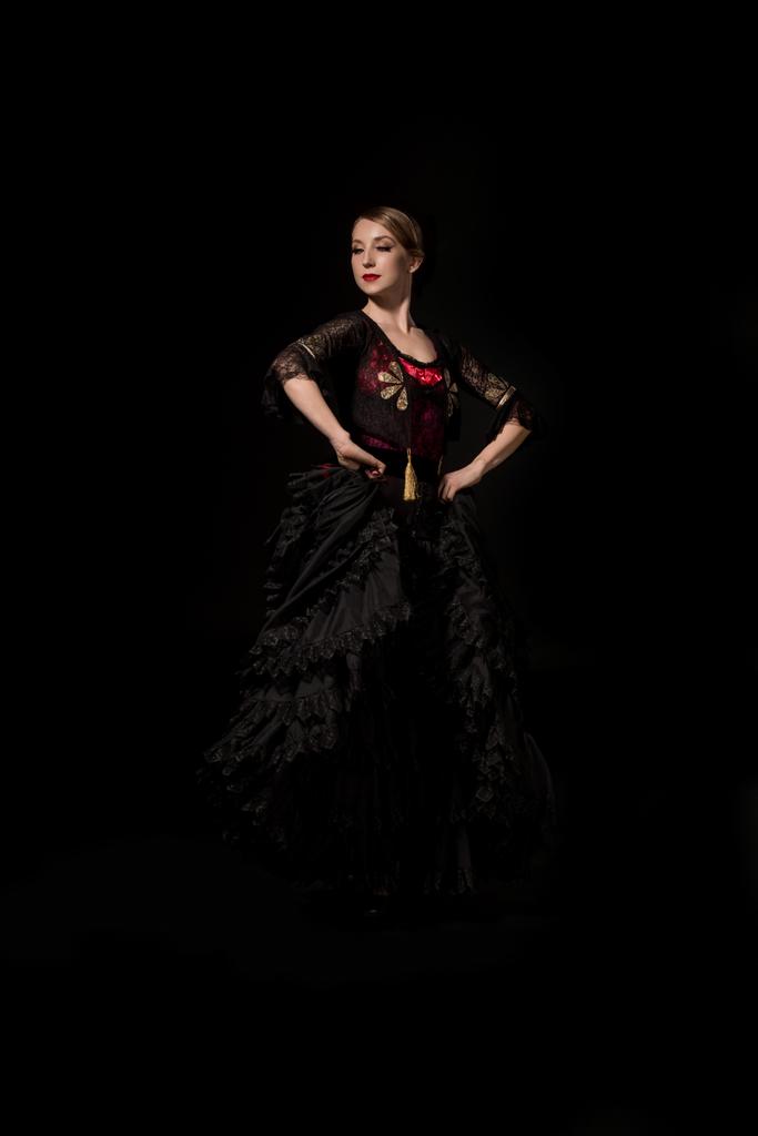 elegant and beautiful flamenco dancer with hands on hips isolated on black - Photo, Image