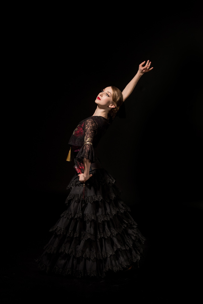 elegant dancer with hand on hip dancing flamenco isolated on black  - Photo, Image