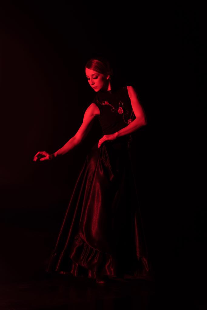 červené osvětlení na krásné mladé ženy tanec flamenco izolované na černé   - Fotografie, Obrázek